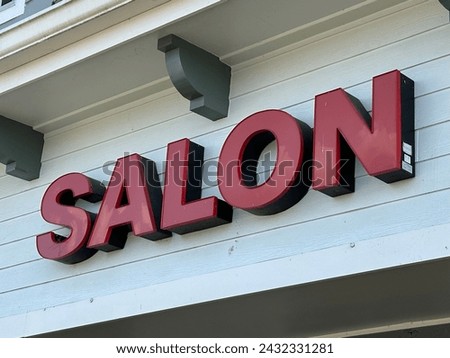 Salon store front sign in red illuminated letters