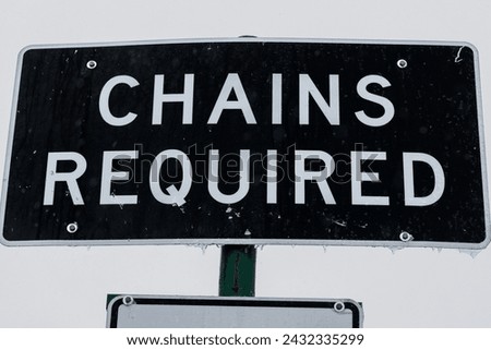 Highway sign in Sierra Nevada mountains that reads,"CHAINS REQUIRED." 