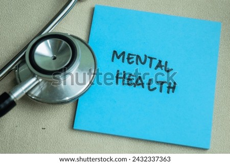 Concept of Mental Health write on sticky notes with stethoscope isolated on Wooden Table.