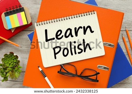 learn Polish Top view of empty notepad and various office supplies on wooden table Royalty-Free Stock Photo #2432338125