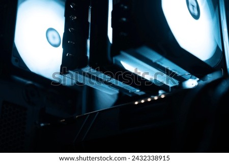 Detail of the interior of the PC gamer case. Motherboard, CPU tower cooling, memory, graphic card and RGB fans. professional gaming computer. Gaming PC with RGB LED lights hardware. Royalty-Free Stock Photo #2432338915