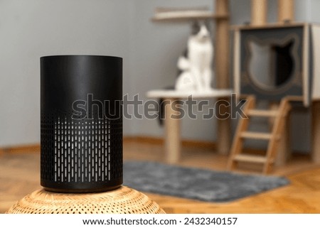 air purifier in the area with pets or cat. Air Pollution Concept. Air purifier, filters out invisible viruses, allergens or pollutants in the house on a cat tree background. Cute cat and Air purifier Royalty-Free Stock Photo #2432340157
