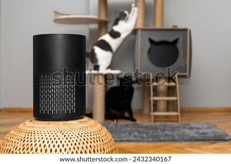 air purifier in the area with pets or cat. Air Pollution Concept. Air purifier, filters out invisible viruses, allergens or pollutants in the house on a cat tree background. Cute cat and Air purifier Royalty-Free Stock Photo #2432340167