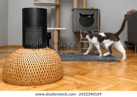 air purifier in the area with pets or cat. Air Pollution Concept. Air purifier, filters out invisible viruses, allergens or pollutants in the house on a cat tree background. Cute cat and Air purifier Royalty-Free Stock Photo #2432340169