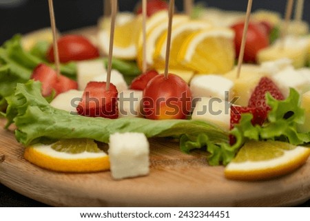 Fresh summer fruit kebab on a slate plate. vitamin sweet food background. Delicious appetizers with cheese and mix ingredients  Royalty-Free Stock Photo #2432344451