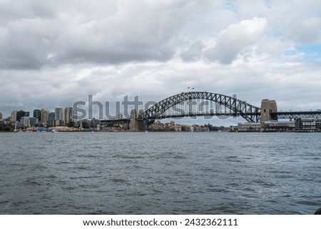 Harbor bridge and Sydney skyline on a cloudy day.