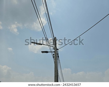 Electrical poles and wires against the sky