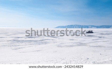 A hovercraft on frozen lake Baikal the world's deepest lake located in southern Siberia, Russia. Hovercraft can fly over any flat surface, so over snow, ice and water. Royalty-Free Stock Photo #2432414829