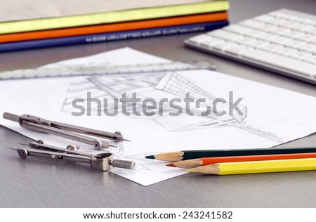Working place of designer. Well organized working place with devises and supplies and drawing of house plan in the middle