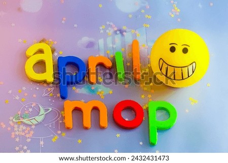 Background design for April mop , colorful letter with yellow emoji 