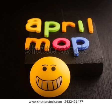 Background design for April mop , colorful letter with yellow emoji 