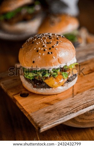 High-angle of a hamburger with beef patty, and vegan on a wooden cutting board Royalty-Free Stock Photo #2432432799