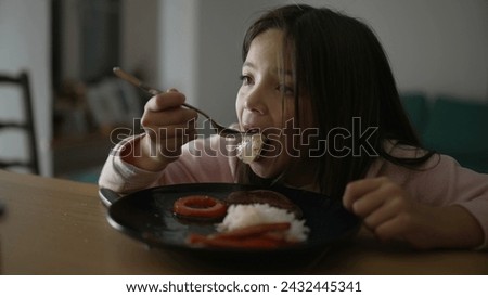 Little girl eating dinner at home. Child enjoying evening homemade plate. 8 year old kid dining Royalty-Free Stock Photo #2432445341