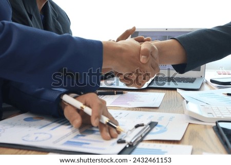 Close up of hands of business people working together in a conference room, brainstorming, discussing and analyzing and planning business strategies.