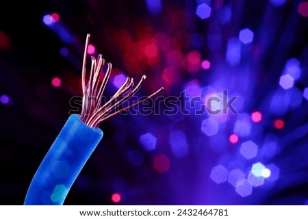 One electrical wire against dark background with blurred lights, closeup. Space for text
