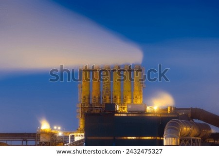 Heavy industry. View of production and factory. Panoramic view of the factory at night. Emission of harmful substances into the atmosphere. Photo for background, advertising and wallpaper.