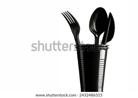 Disposable black plastic cup and cutlery on a white background. Ecology and recycling concept. Royalty-Free Stock Photo #2432486315