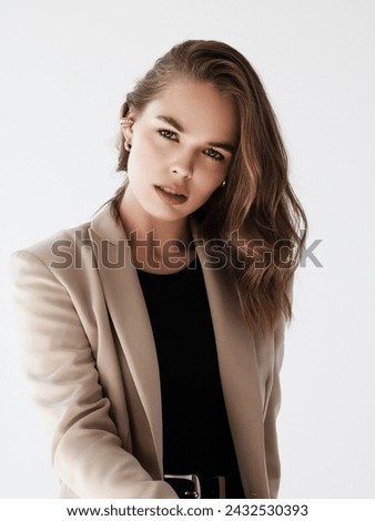 Fashion and beauty model . Picture of young beautiful woman manager in beige suit. Young brunette curly woman in beige suit. Pretty tanned lady