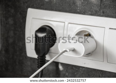 White socket in the wall with cables Royalty-Free Stock Photo #2432532757
