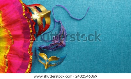 Beautiful white and multicolor carnival masks on a blue background. Purim, Mardi Gras holiday concept. View from above