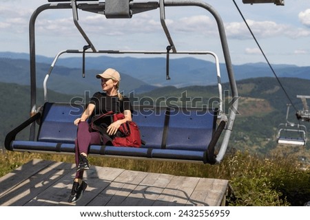 vacation in Carpathian mountains. woman on the lift in the mountains in summer. Ukrainian ski lift transportation. Royalty-Free Stock Photo #2432556959
