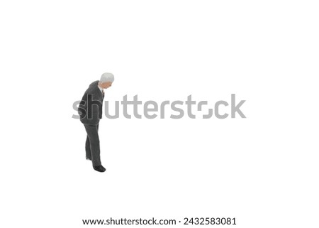 miniature figurine of a senior businessman standing on a white background