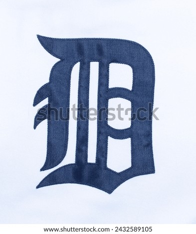 A navy blue letter D in Collins Old English Regular font.  Fabric stitched Detroit tigers American professional major league baseball brand logo photo from their jersey.  isolated on white background
