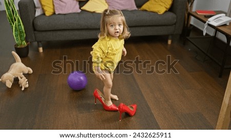 Cute blonde girl trying on red heels in a cluttered living room, depicting childhood innocence and playfulness at home.