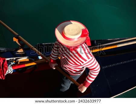 Venetian gondolier with white and red hat rowing on gondola boat on grand canal in Venice in Italy in Europe Royalty-Free Stock Photo #2432633977