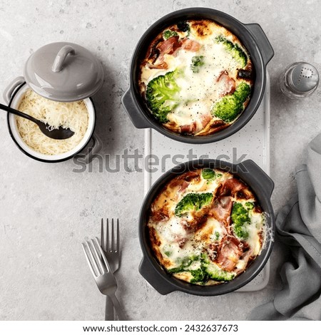 Broccoli casserole in a grey ceramic baking dish on a concrete background. Selective focus