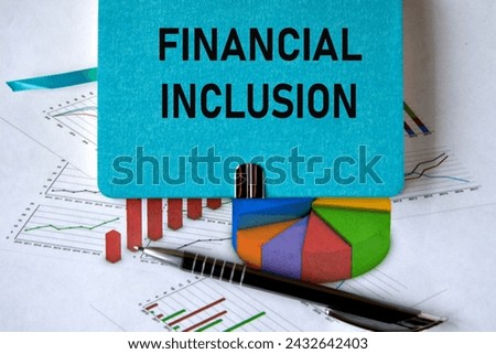 FINANCIAL INCLUSION - words on a green piece of paper on the background of a chart and a pen. Business concept