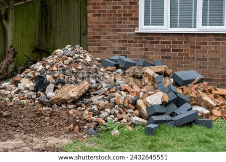 Building rubble in a suburban front garden during a home renovation Royalty-Free Stock Photo #2432645551