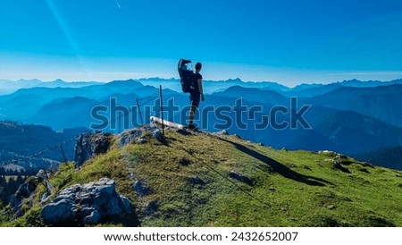 Man with baby carrier looking at magical mountain peaks of Karawanks and Julian Alps seen from Goldeck, Latschur group, Gailtal Alps, Carintha, Austria. Mystical atmosphere in Austrian Alps in summer Royalty-Free Stock Photo #2432652007