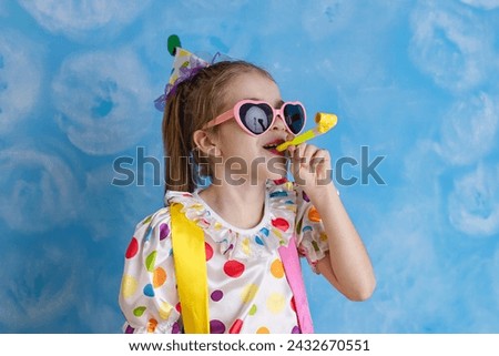 Funny kid clown playing against a bright wall. 1 April Fool's day concept, birthday concept.