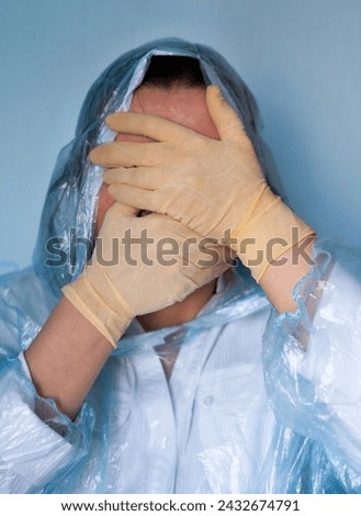 Woman in a protective suit closing her face. Distressed woman. Coronavirus (Covid-19) disease outbreak.  Royalty-Free Stock Photo #2432674791