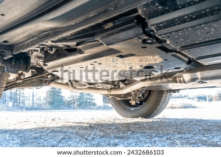 View of the car from below. All wheel drive trance axle and differential, part of automobile exhaust system and suspension. Pre purchase inspection services, and road service. Royalty-Free Stock Photo #2432686103