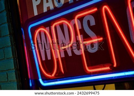 A fluorescent open sign in a local business window.