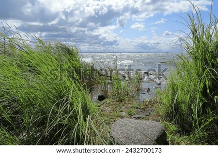 Hindens rev at Vänern. The biggest lake in Sweden. Large wet rocks. Windy outside this summer day. Near Lidköping. Royalty-Free Stock Photo #2432700173