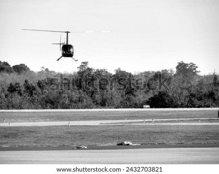 An aviation photograph of a helicopter flying at the Winter Haven, Floria Airport. 