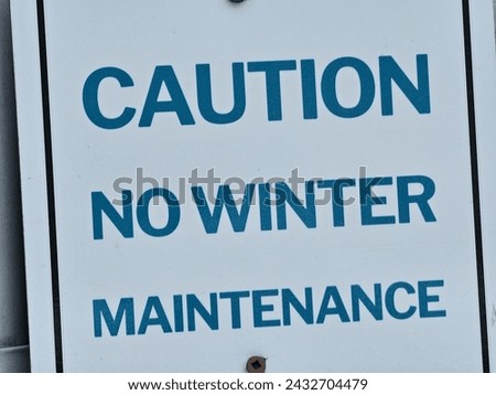 A closeup of a caution no winter maintenance sign.