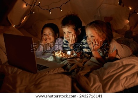 Children, computer and watch in tent at night with movies, film or cartoons for holiday adventure or vacation. Young boy, girl or kids with lights, pillows and blanket at home on laptop for Netflix