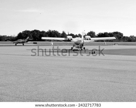 An aviation photograph of a twin engine aircraft landing and taking off from a Winter Haven Airport Runway. 