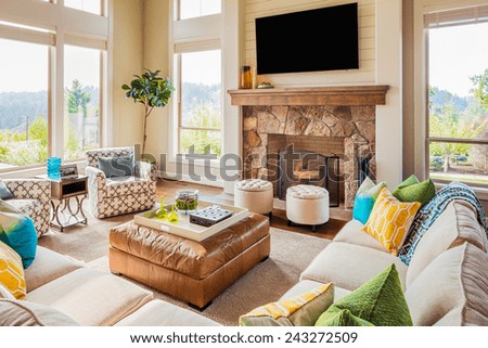 Beautiful Furnished Living Room Interior in New Luxury Home with Fireplace, Couches, Chairs, and Television Royalty-Free Stock Photo #243272509