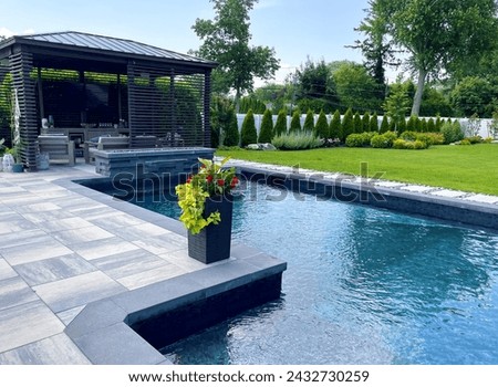 Stunning luxury backyard view of pool with sundeck, chaise lounges, garden, pergola   Modern and sleek, it has an effortless boho inspired, resort like feel. Inspired by Tulum, Mexico's eco-chic feel. Royalty-Free Stock Photo #2432730259