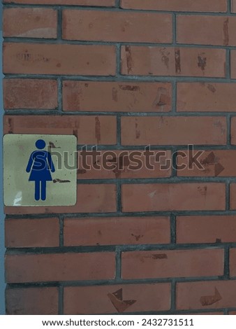 women's restroom sign on the brick wall.