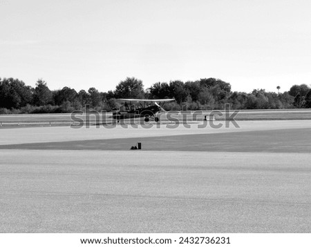 A black and white photo of an unknown type of Biplane at Winter Haven airport in Winter Haven, Florida during early 2017. 