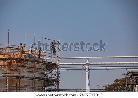 Construction workers installing scaffolding storage tank Oil​ refinery​ and​ plant and tower column of Petrochemistry industry in oil​ and​ gas​.