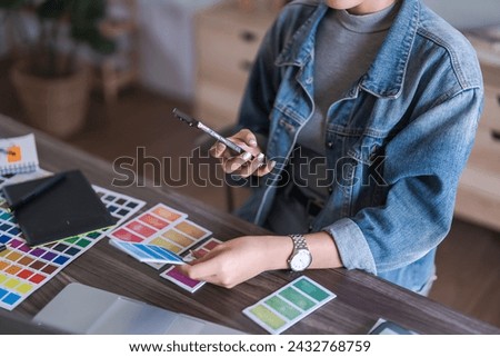 Graphic designer women taking photo color swatch samples on smartphone for designing graphic design.