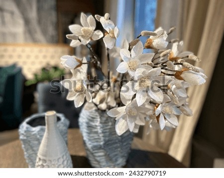 spring large bouquet with white magnolia flowers in a vase on the table in the home interior on the background of a window with curtains, the concept of decorating the home interior with plants. 