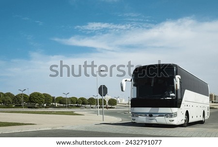 White Modern comfortable tourist bus driving through highway. Travel and coach tourism concept. Trip and journey by vehicle. White city bus goes along street. New modern bus with tinted windows